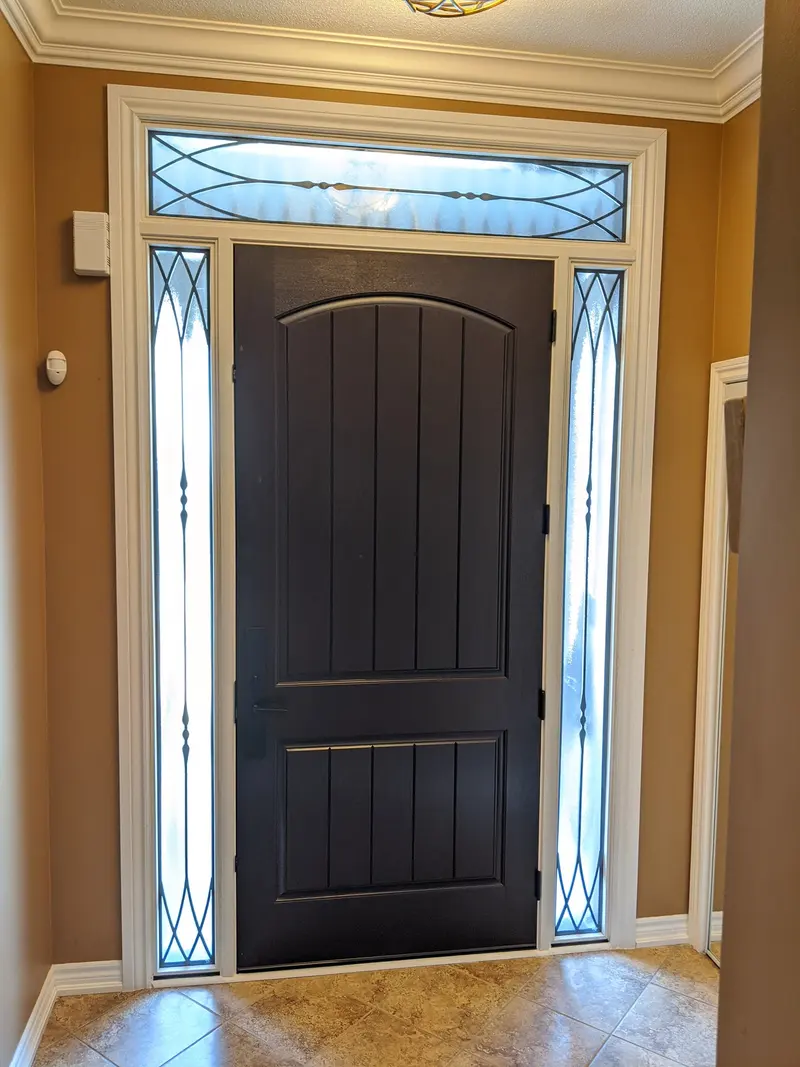 Stained fiberglass entry door with arched transom and decorative sidelites