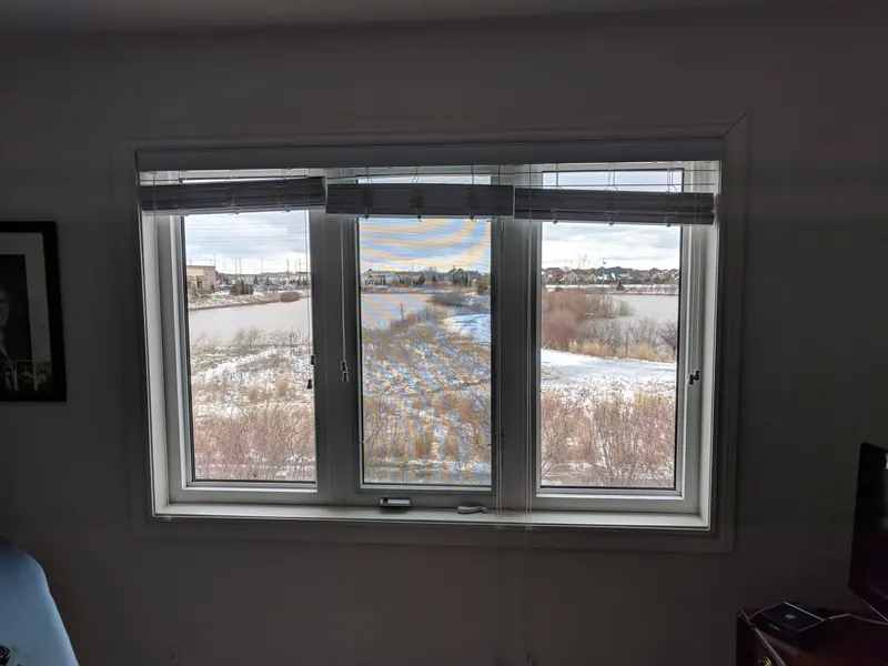After: the same window with clear new glass and a sharp pond view