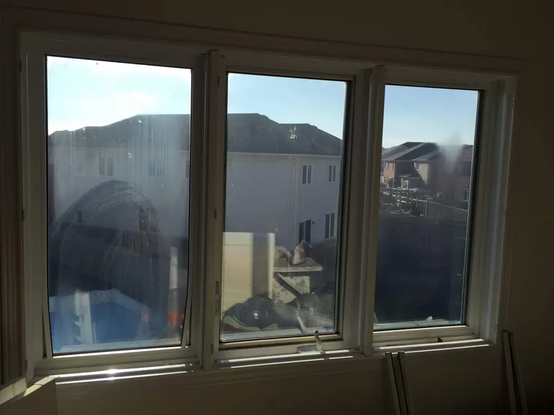 Before: three-panel window with hazy, streaked glass