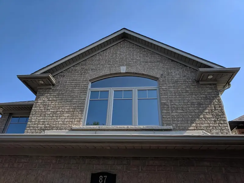 New vinyl window with arched top in a brick gable