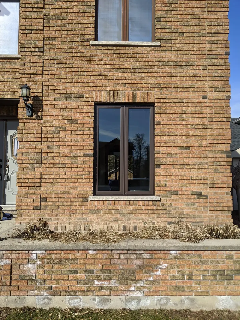New black-frame vinyl window in a brick wall
